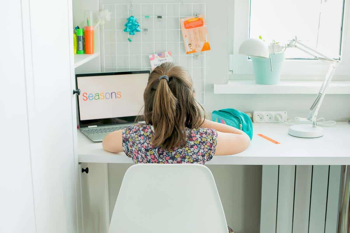 Homeschool office setup with a small desk, colorful art supplies, and a laptop displaying 'Seasons,' perfect for homeschool room ideas.