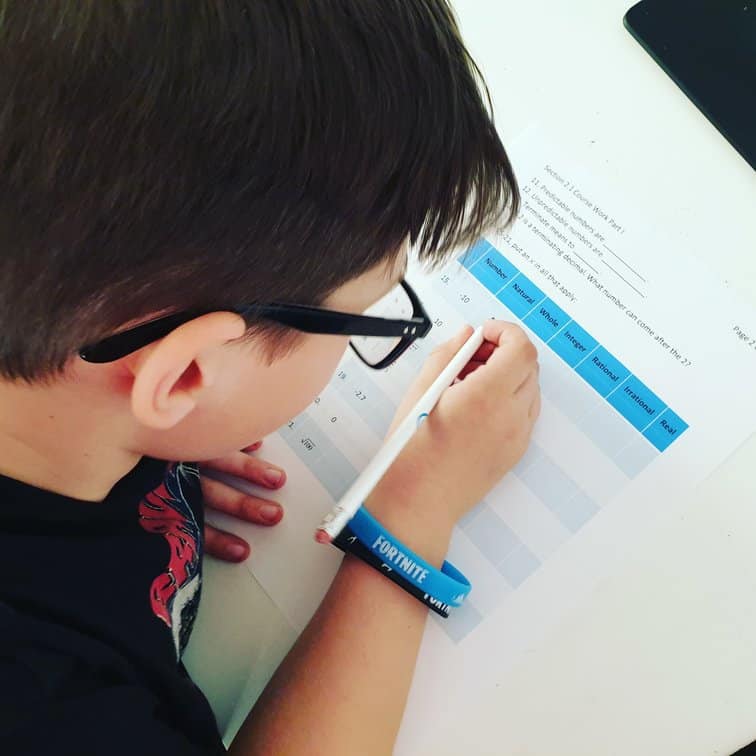 boy working on Mr D Math pre algebra questions worksheet