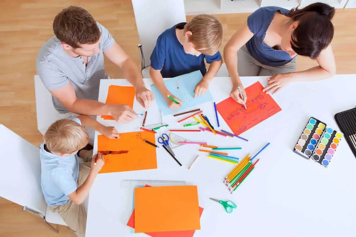 A family gathered around a table, engaging in a homeschooling session.