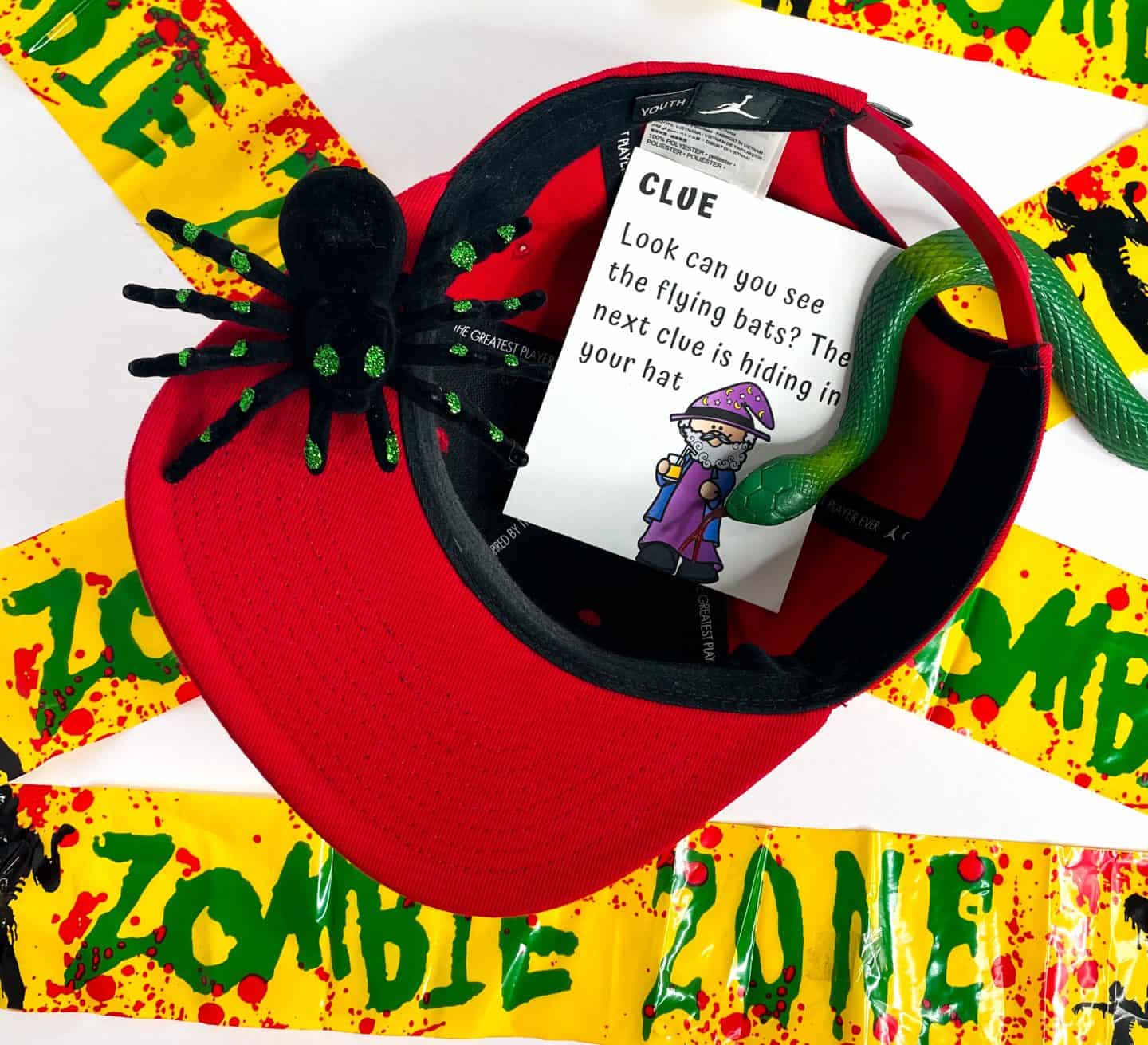 halloween treasure hunt clue in a red hat with a spider and a snake