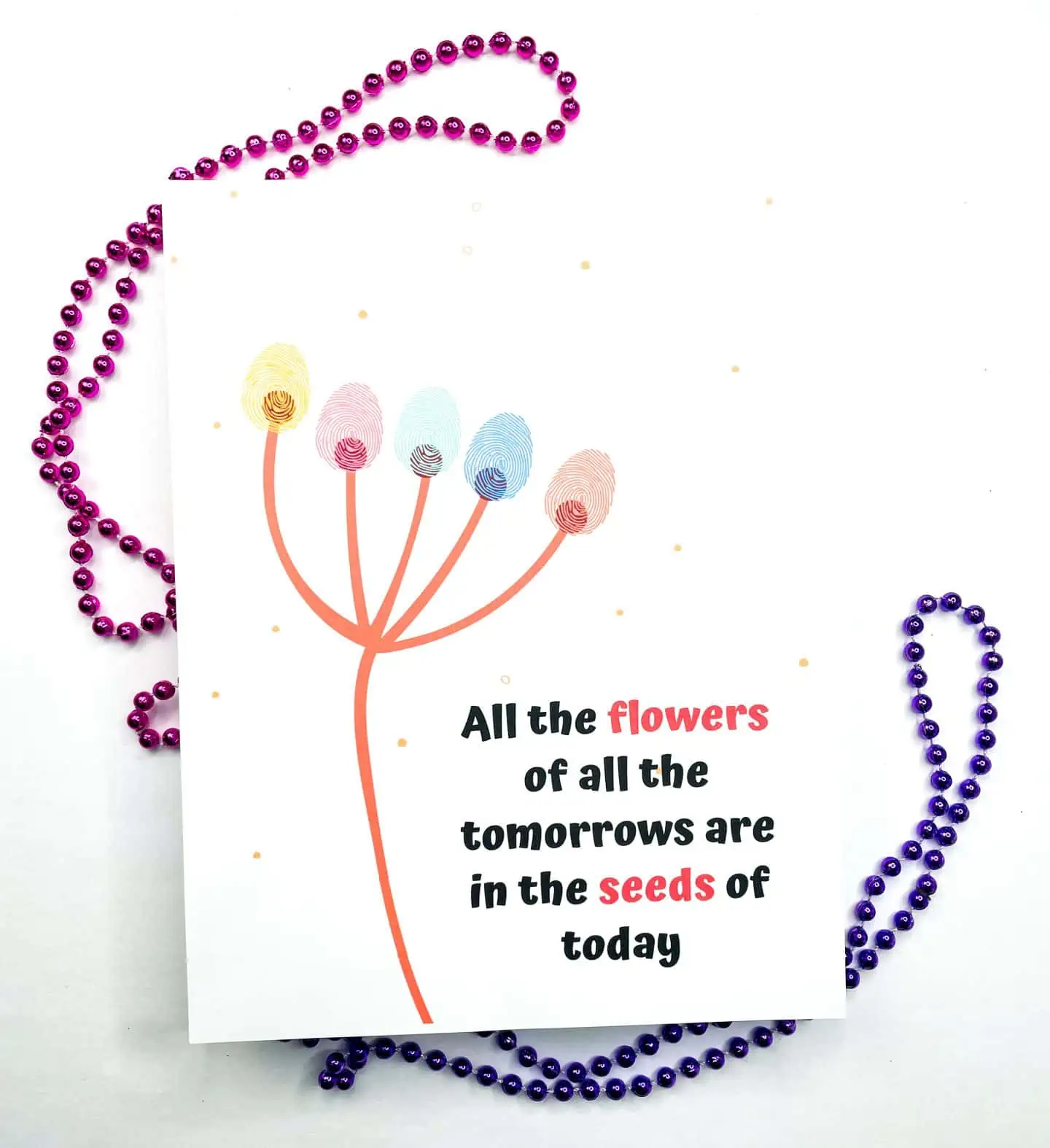 A handprint art printable with a red and pink fingerprint flower design and the inspirational phrase "All the flowers of all the tomorrows are in the seeds of today," with open paint pots and a paintbrush to the side.

