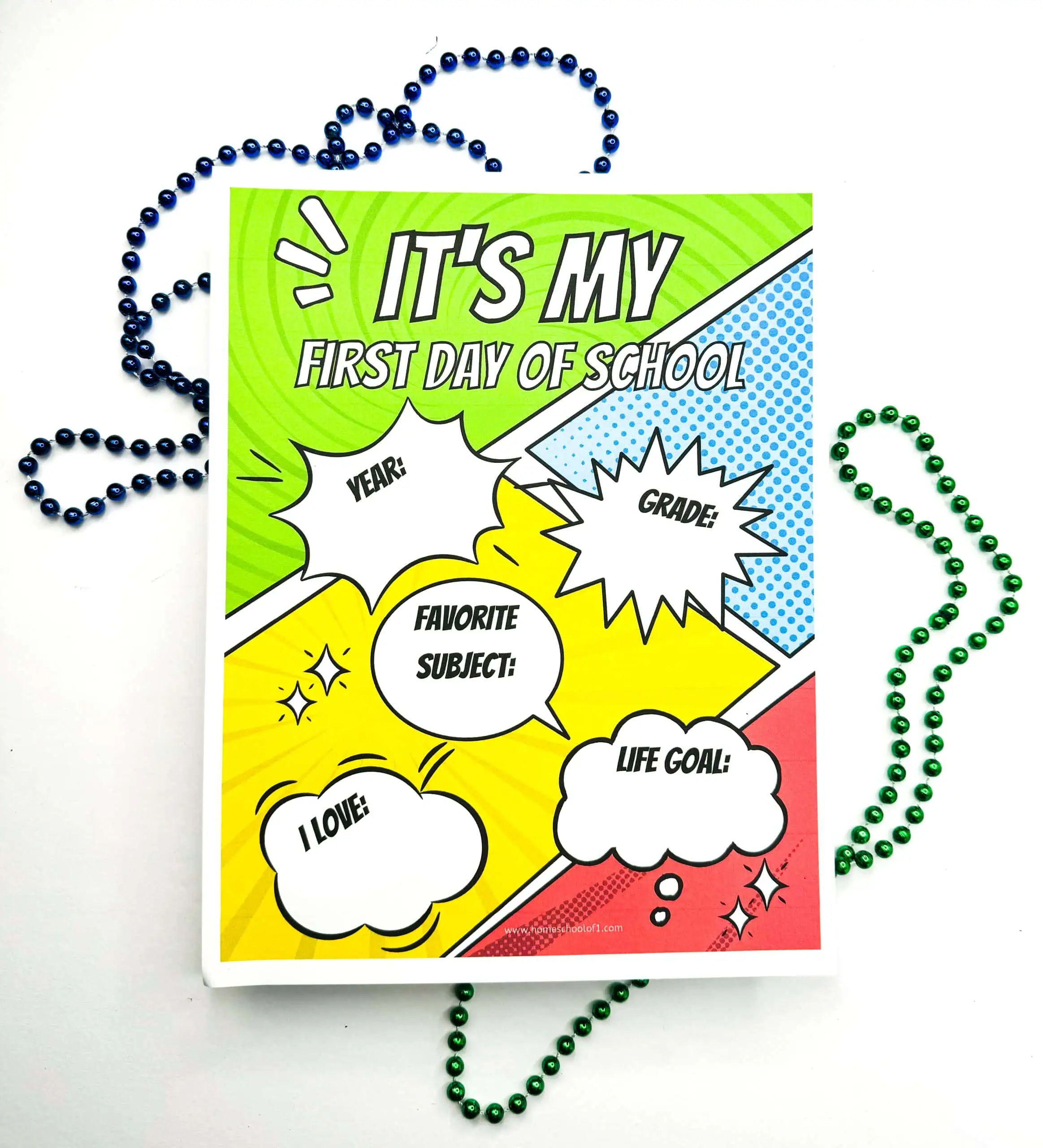 A 'First Day of School' sign with a vibrant green, blue, and yellow comic book design. It includes speech bubbles for 'YEAR,' 'GRADE,' 'FAVORITE SUBJECT,' 'I LOVE,' and 'LIFE GOAL,' accented by a green beaded necklace. 