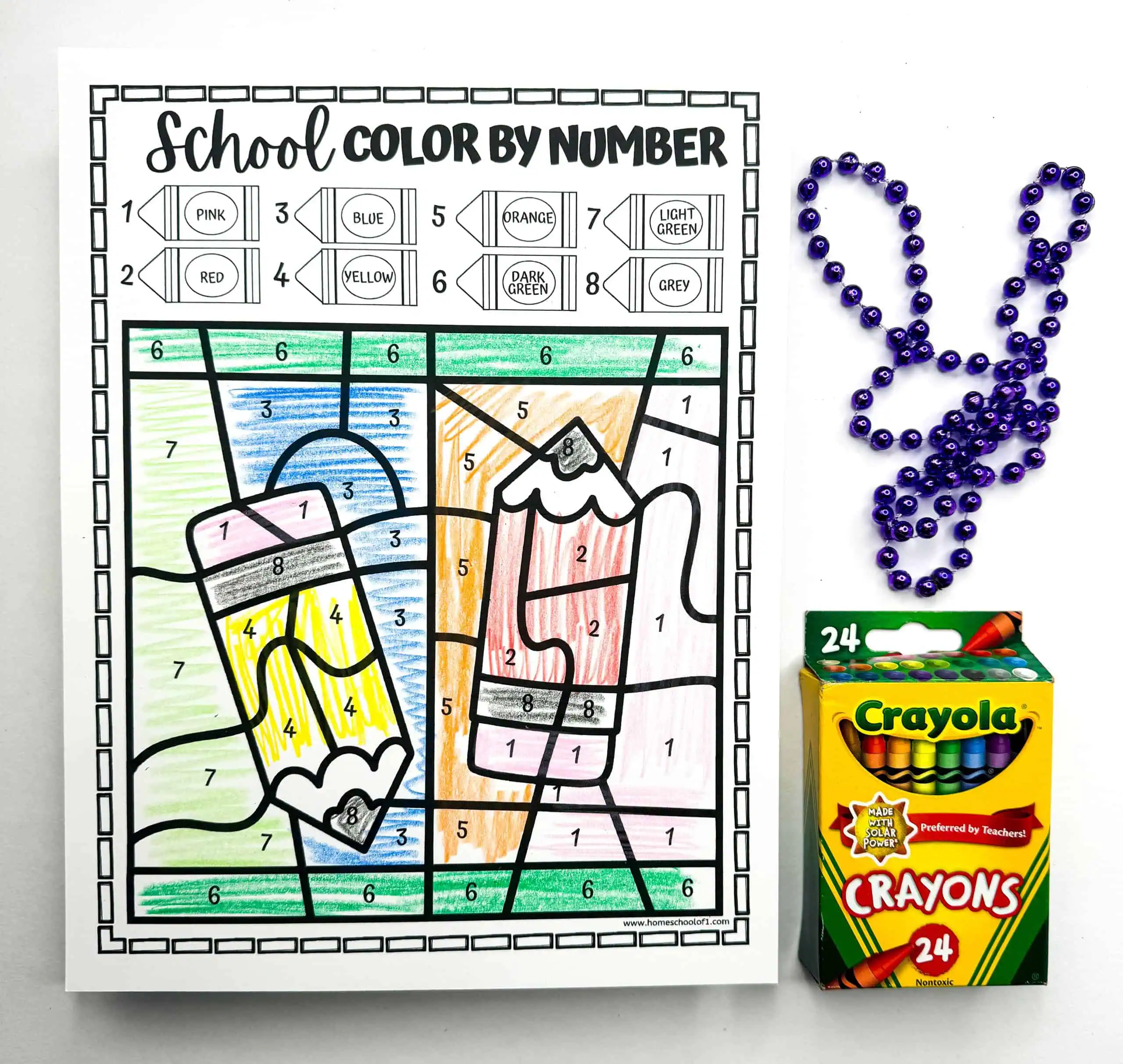 This worksheet shows 2 pencils vcolor by number activity, where each segment is filled with colors based on the guide. A rabbit-shaped bead design and a box of Crayola crayons are part of the educational setup.