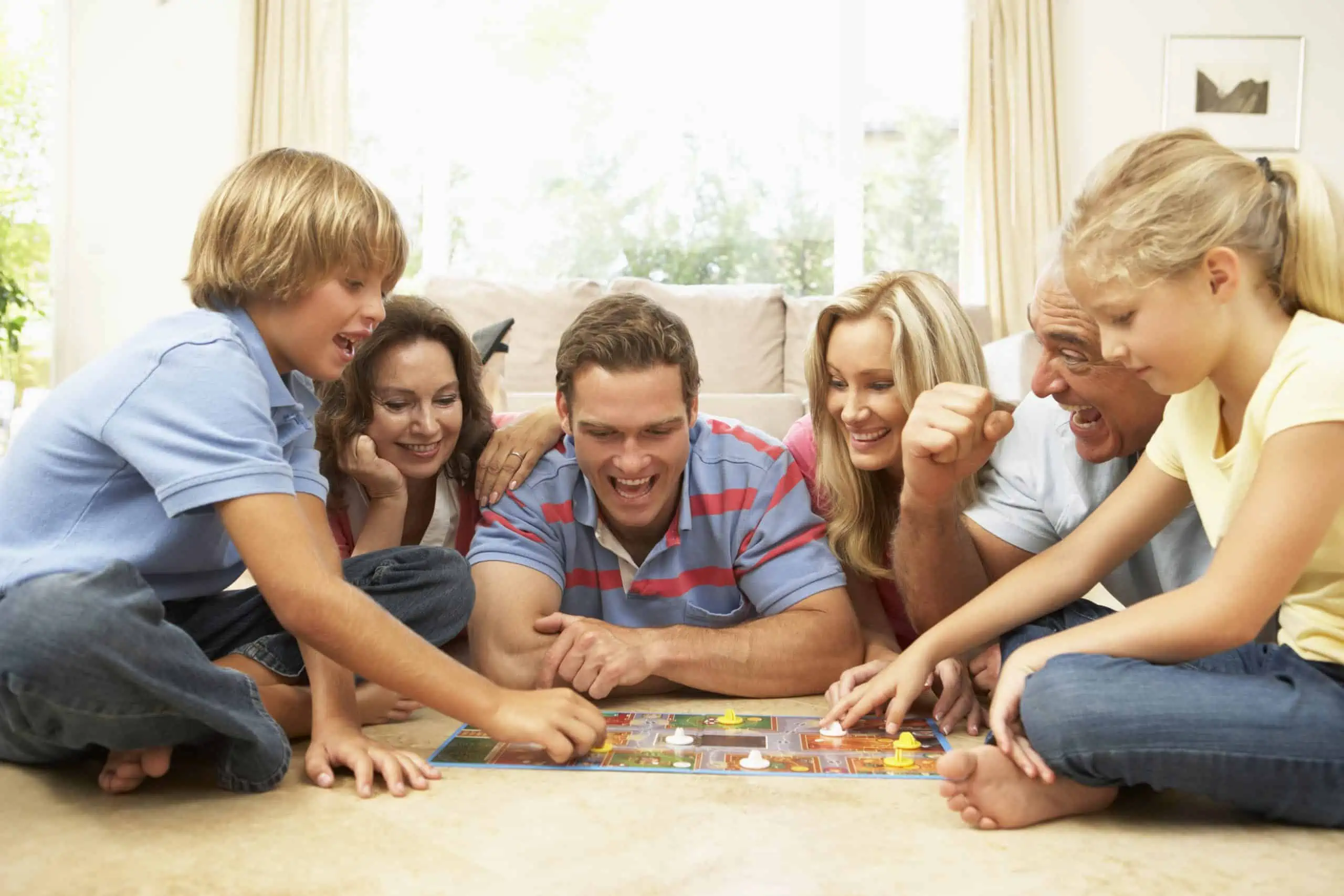 Family Playing Board Game At Home With Grandparents Watching