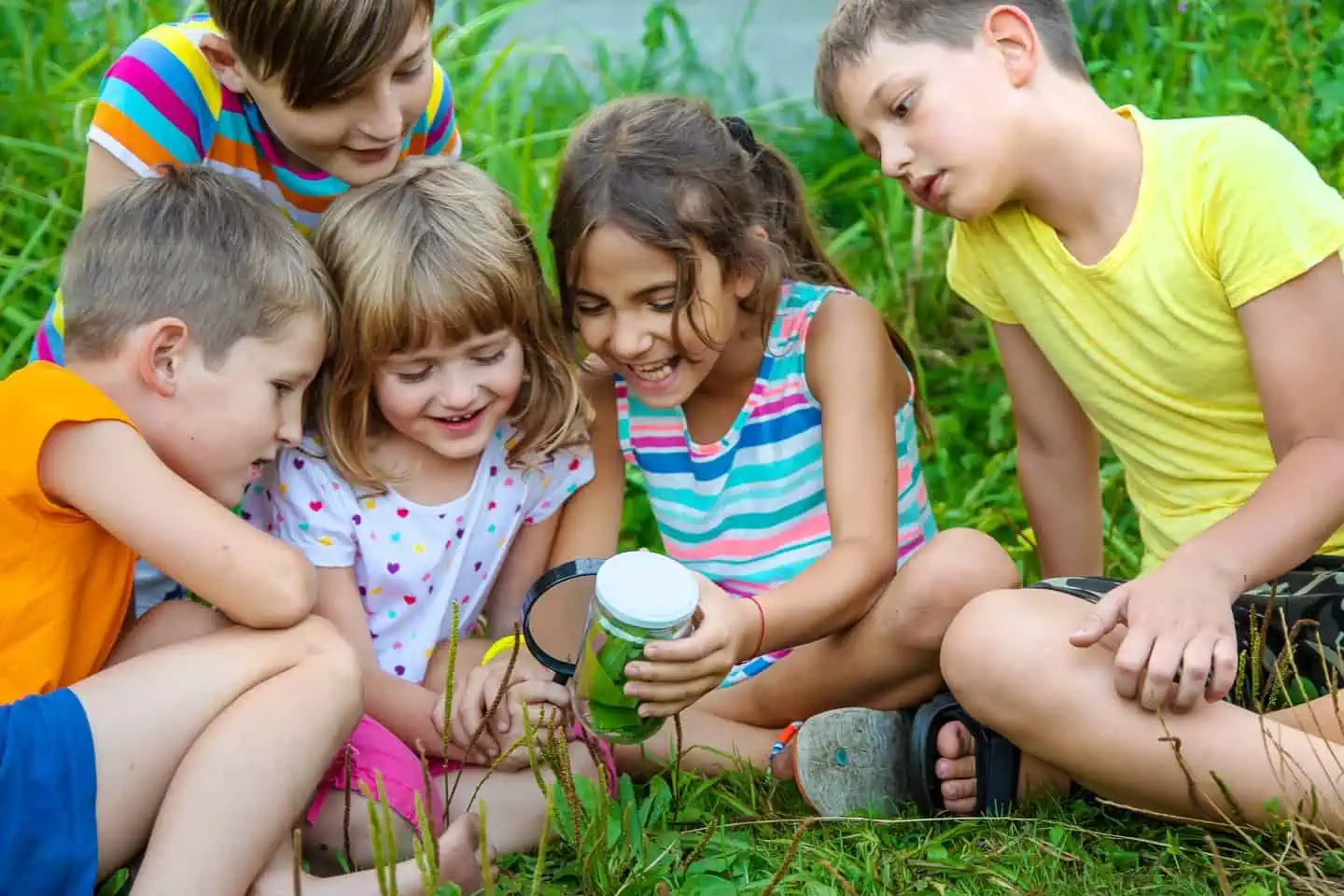 Children look at a magnifying glass on the nature. Selective focus. Nature.