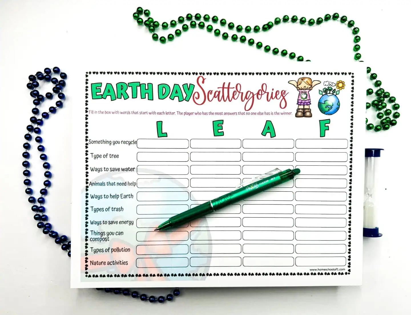 A single Earth Day Scattergories sheet filled out with 'LEAF' as the word prompt, accompanied by green and blue Mardi Gras beads and a green pen, set against a white background