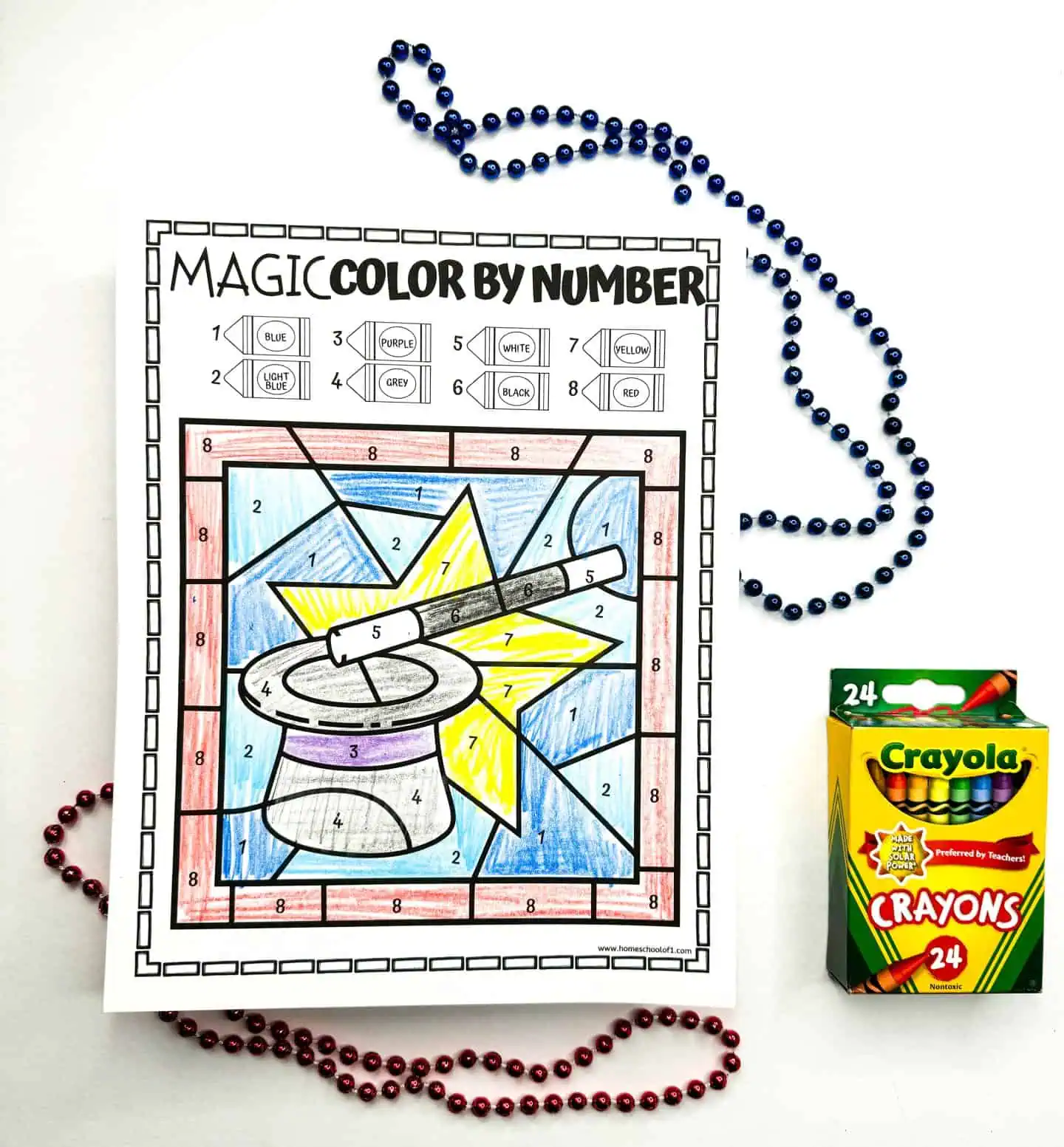 Hand-colored number-guided drawing of a magician's top hat surrounded by a starry design, crayon box, and colorful beads