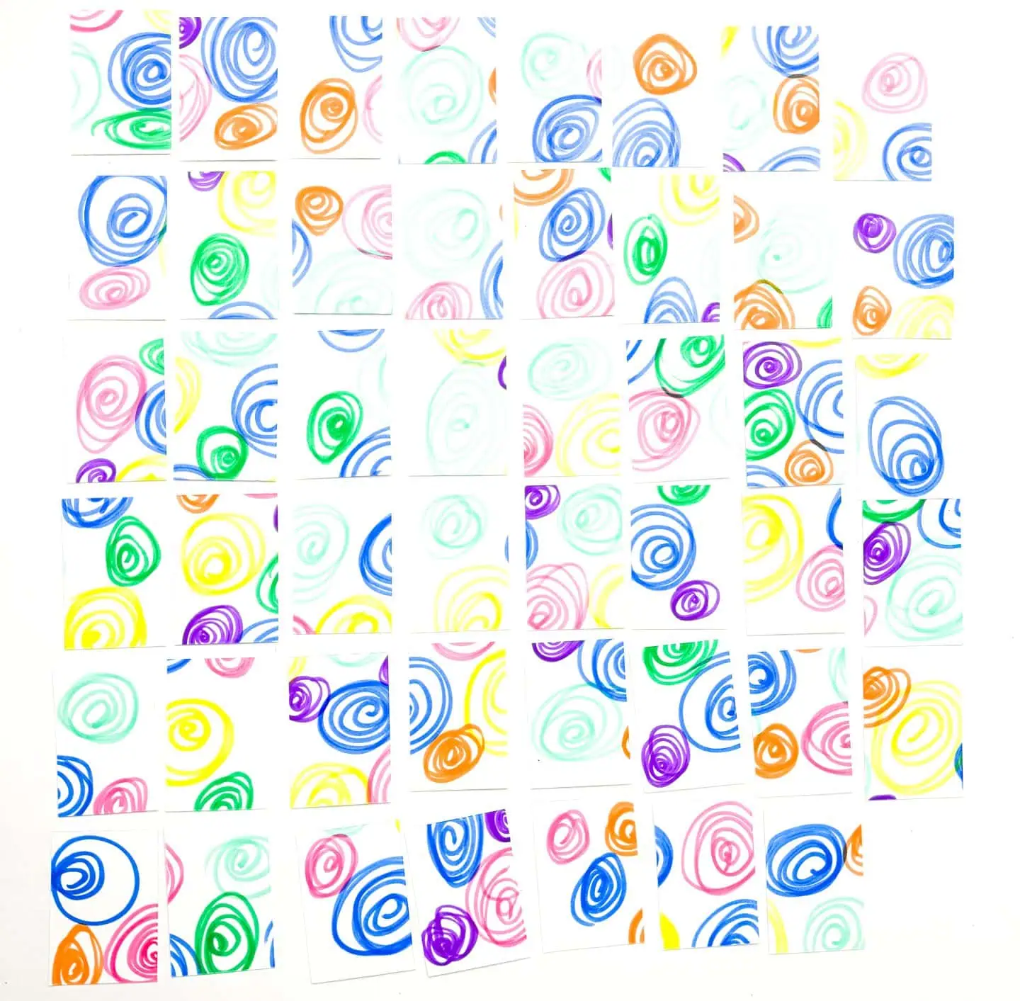 Spread out 'Clothes Memory Game' cards with vibrant swirls on the back, ready for a matching game, with no visible clothing items facing up, implying the game's start.