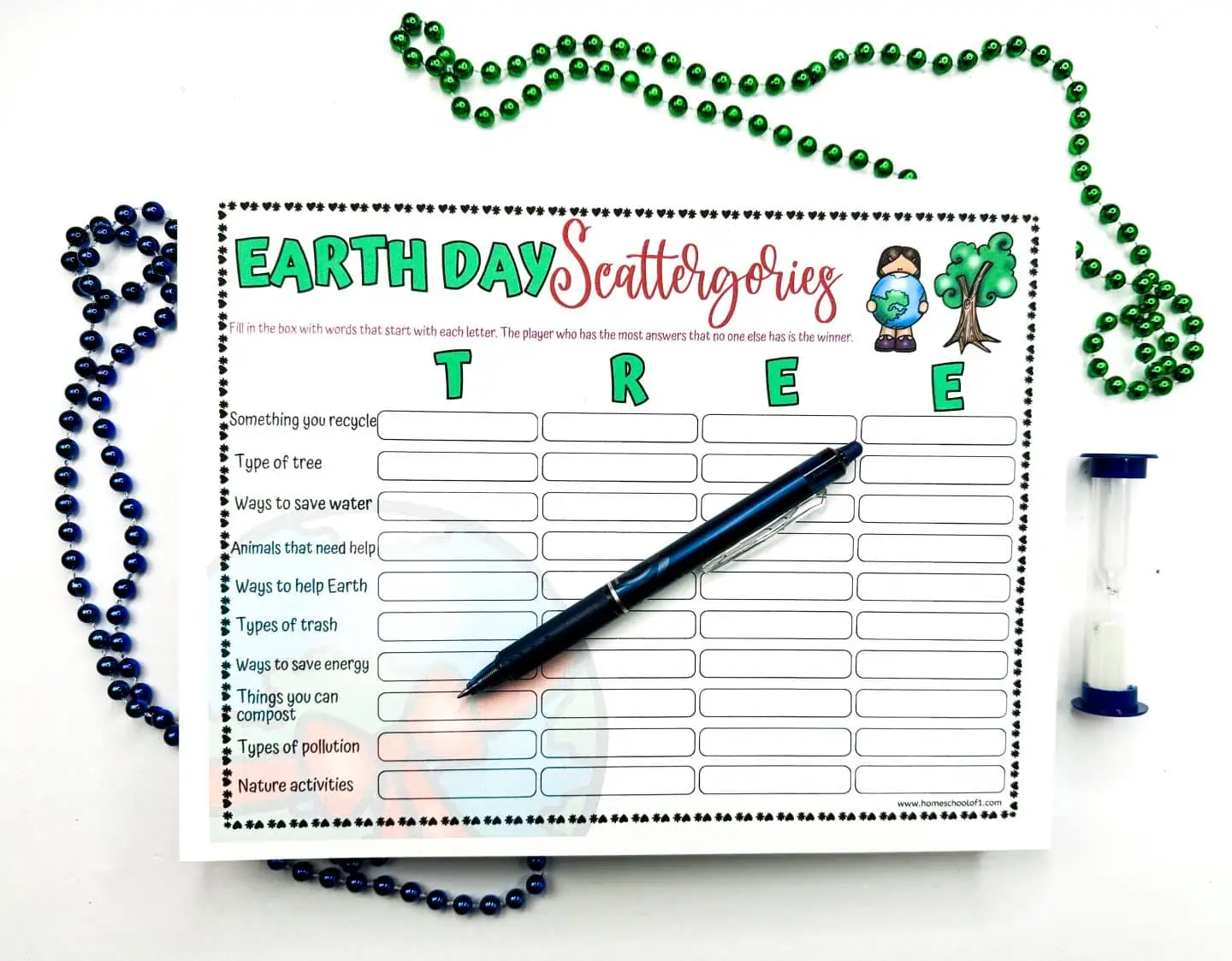 An 'Earth Day Scattergories' game sheet with the word 'TREE' in the center, flanked by festive Mardi Gras necklaces and a blue pen, highlighting an environmentally conscious activity