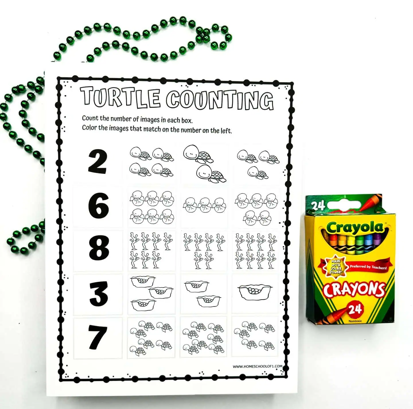 Printable worksheet titled 'TURTLE COUNTING' featuring columns with numbers 2, 6, 8, 3, 7 and corresponding sets of turtles to count and color. A box of Crayola crayons and decorative beads are placed next to it.