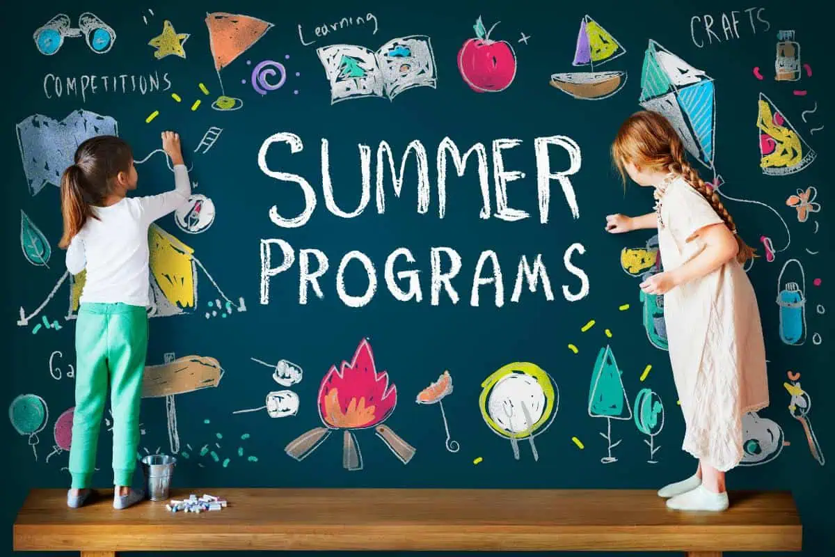 Two children drawing on a chalkboard with the words 'Summer Programs' surrounded by colorful drawings of campfires, boats, and crafts, highlighting summer learning activities.